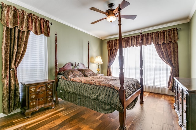 bedroom with hardwood / wood-style flooring, ceiling fan, and crown molding