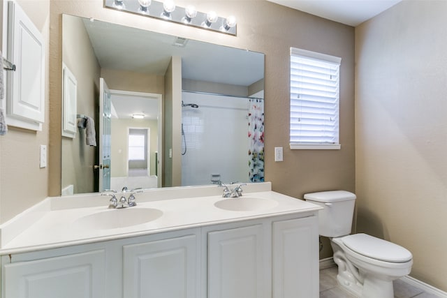 bathroom with tile patterned floors, vanity, toilet, and walk in shower