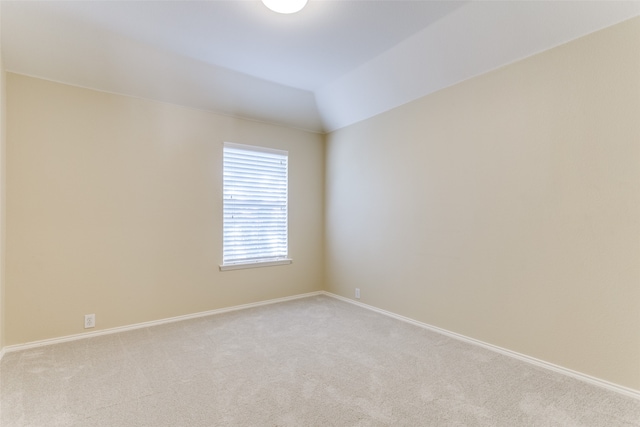 spare room with lofted ceiling and light carpet