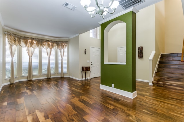 interior space with a chandelier, dark hardwood / wood-style floors, and ornamental molding