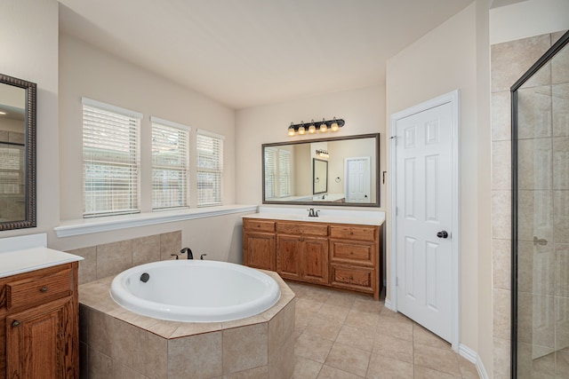 bathroom featuring shower with separate bathtub, vanity, and tile patterned floors