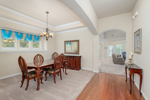 dining space featuring a notable chandelier, a healthy amount of sunlight, crown molding, and hardwood / wood-style flooring