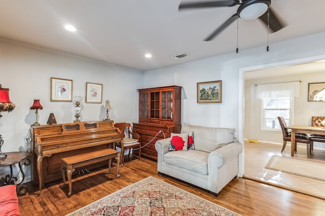 living room with ceiling fan, hardwood / wood-style floors, and ornamental molding