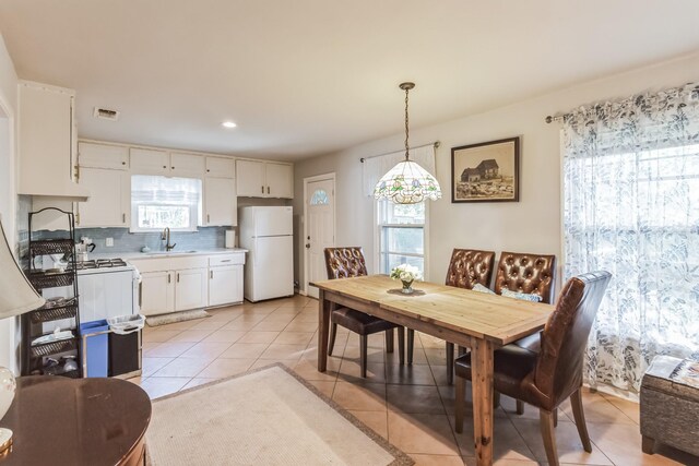 tiled dining room featuring sink