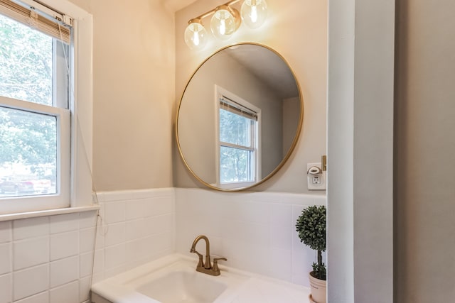 bathroom with sink and tile walls