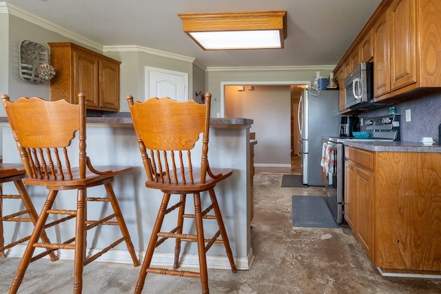 kitchen featuring a kitchen breakfast bar, crown molding, appliances with stainless steel finishes, and tasteful backsplash