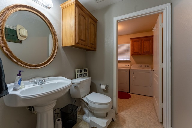 bathroom featuring washer and dryer and toilet