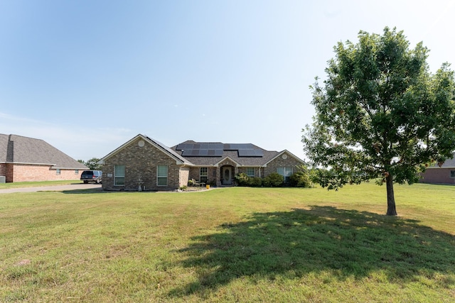 view of front of house with a front lawn and solar panels