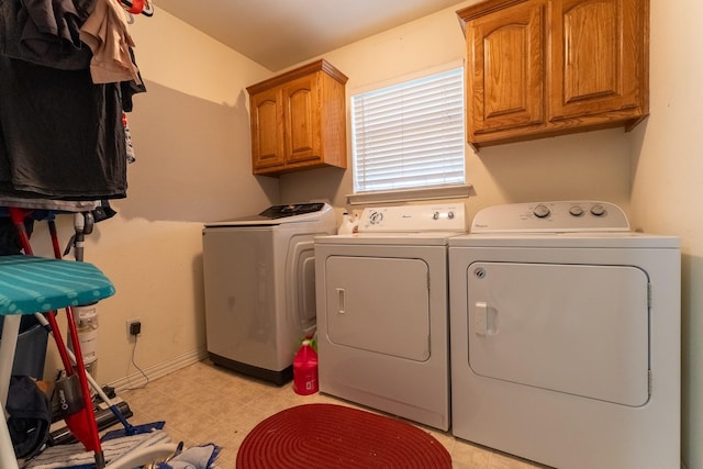 laundry room with washing machine and clothes dryer and cabinets