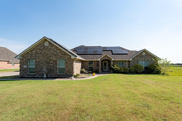 view of front of property featuring solar panels and a front yard