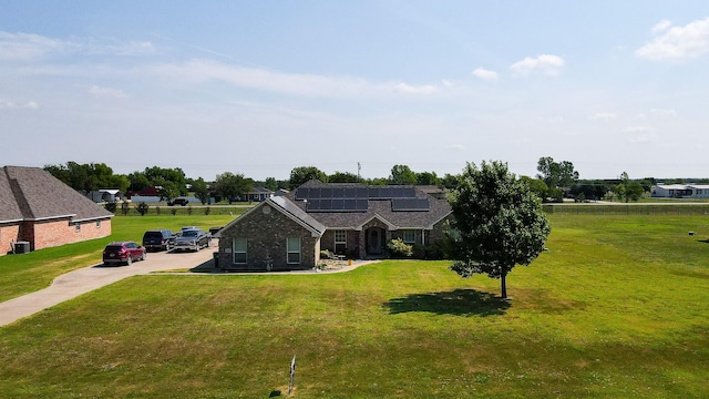 view of front of home featuring a front lawn and solar panels