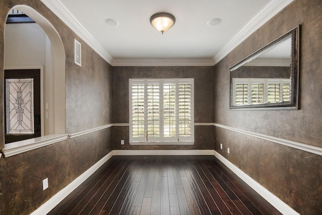 unfurnished room with ornamental molding, a wealth of natural light, and dark wood-type flooring