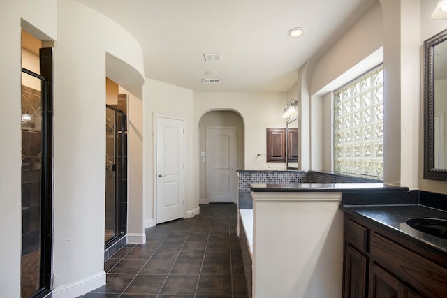 kitchen featuring dark tile patterned flooring, kitchen peninsula, and a wealth of natural light