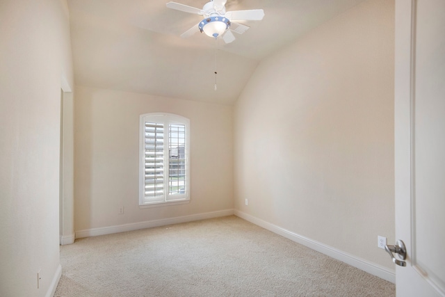 carpeted spare room with vaulted ceiling and ceiling fan