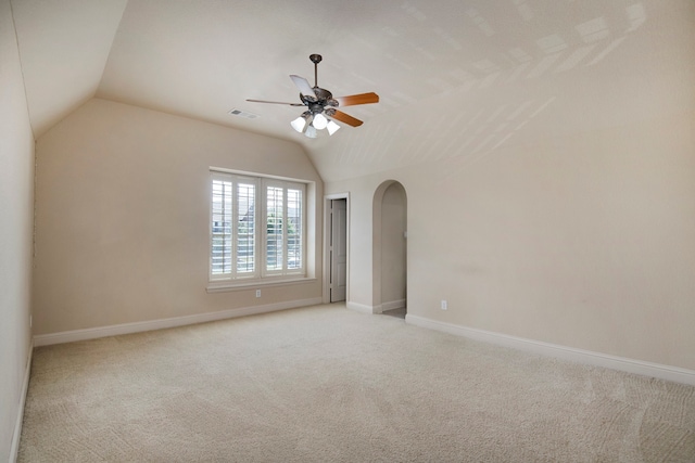 empty room featuring light colored carpet, ceiling fan, and lofted ceiling