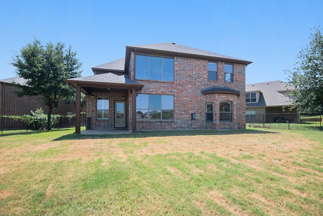 back of property with a patio area and a yard