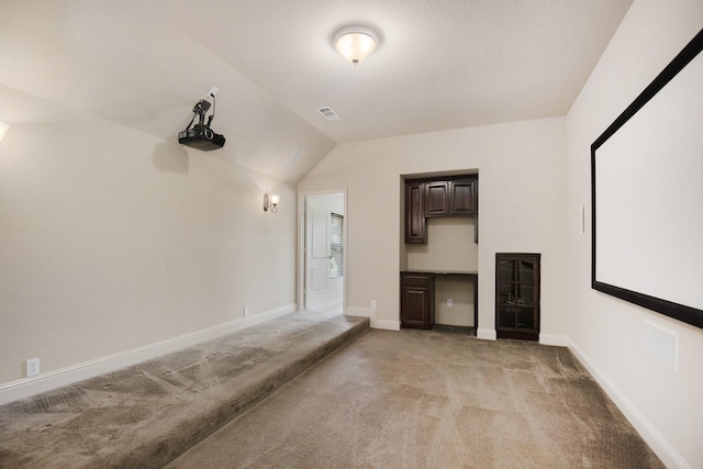 cinema featuring light colored carpet and vaulted ceiling