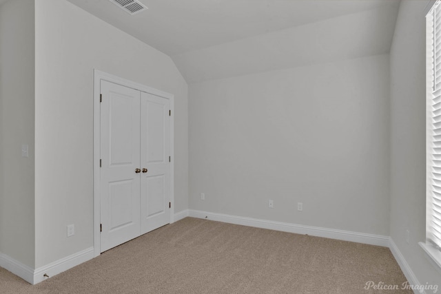 empty room featuring lofted ceiling and light colored carpet