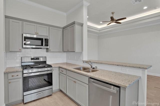 kitchen featuring appliances with stainless steel finishes, sink, kitchen peninsula, and ceiling fan