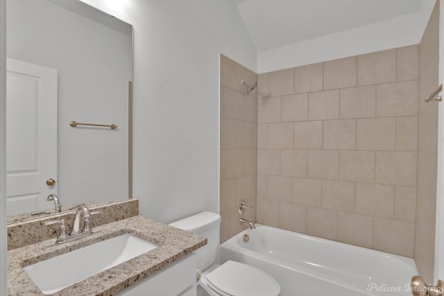 full bathroom featuring vaulted ceiling, vanity, tiled shower / bath, and toilet