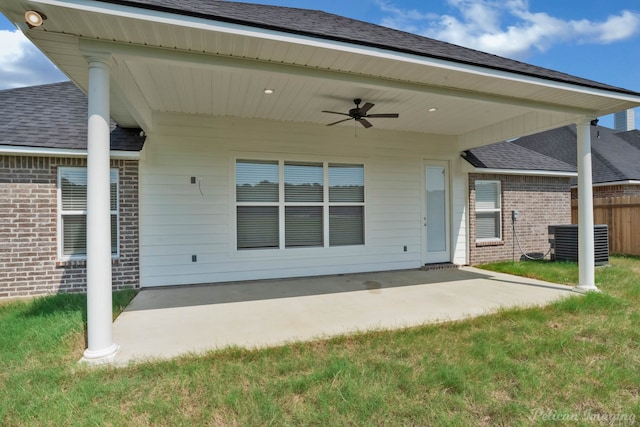 rear view of house featuring ceiling fan, a patio area, and a yard