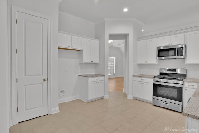 kitchen with light stone counters, white cabinets, light hardwood / wood-style floors, ornamental molding, and stainless steel appliances