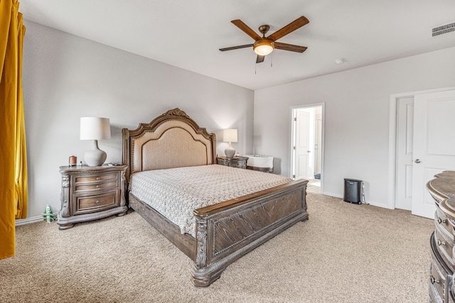 bedroom with light colored carpet, ceiling fan, and ensuite bathroom