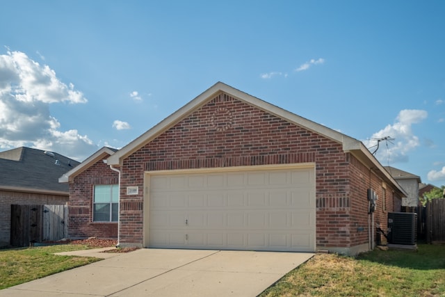 view of front of home with a garage and central AC