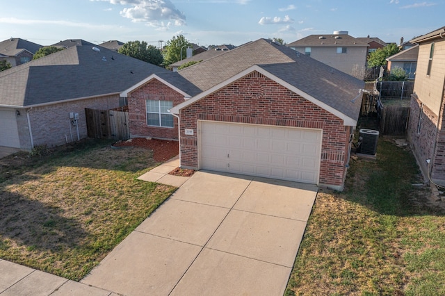 view of front of house featuring a garage, cooling unit, and a front yard