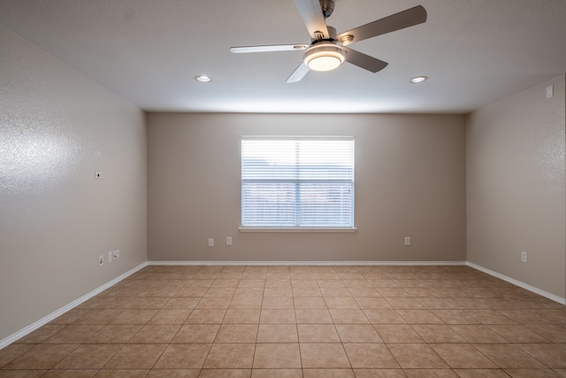 tiled spare room featuring ceiling fan