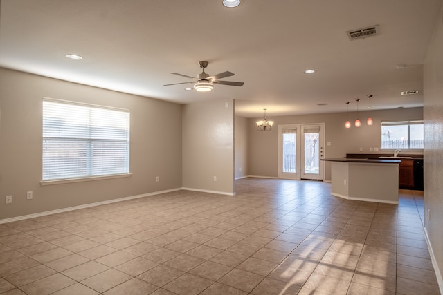 unfurnished living room featuring light tile patterned flooring, sink, and ceiling fan with notable chandelier