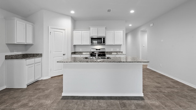 kitchen featuring a center island with sink, white cabinetry, and tile patterned flooring