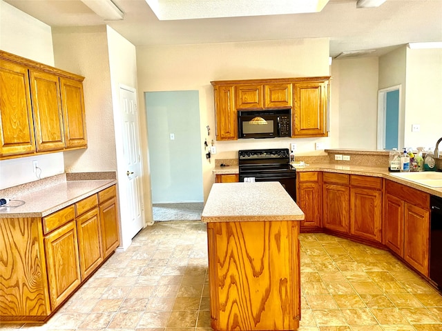 kitchen featuring black appliances, kitchen peninsula, sink, and a center island