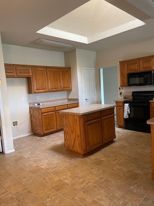 kitchen featuring black appliances, light stone counters, and a center island