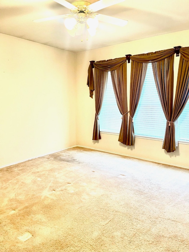 carpeted empty room featuring ceiling fan