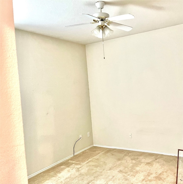 carpeted spare room featuring ceiling fan