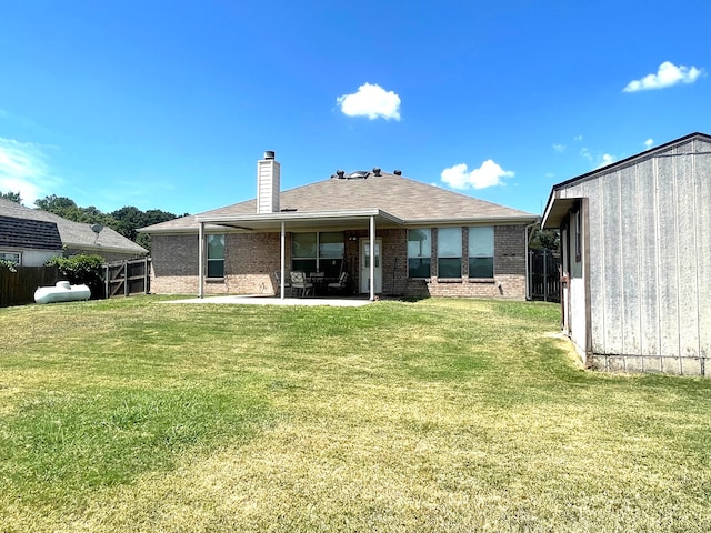 rear view of house with a yard and a patio area