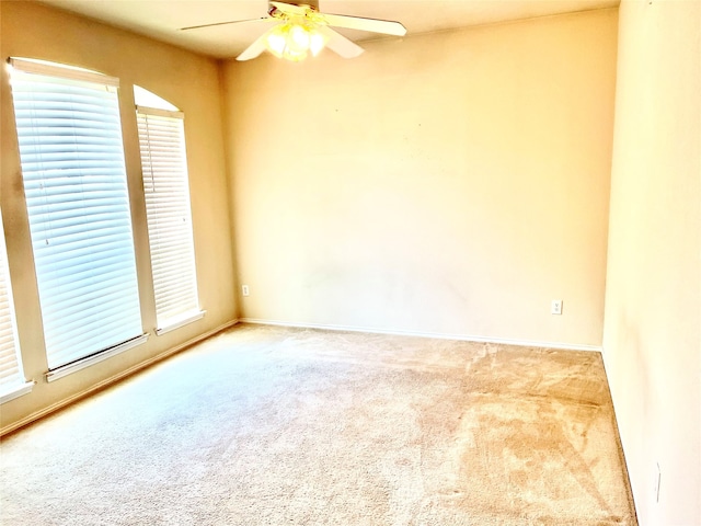 spare room featuring carpet flooring, ceiling fan, and plenty of natural light