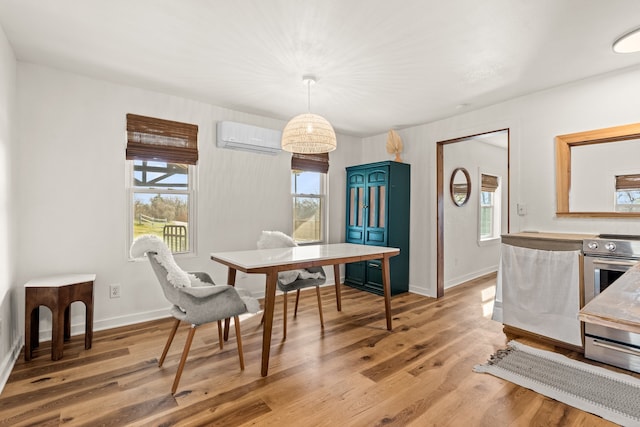 dining area featuring light hardwood / wood-style flooring and an AC wall unit