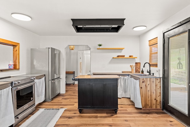 kitchen with sink, stainless steel appliances, and light hardwood / wood-style floors