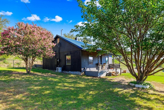 back of house with central AC and a lawn