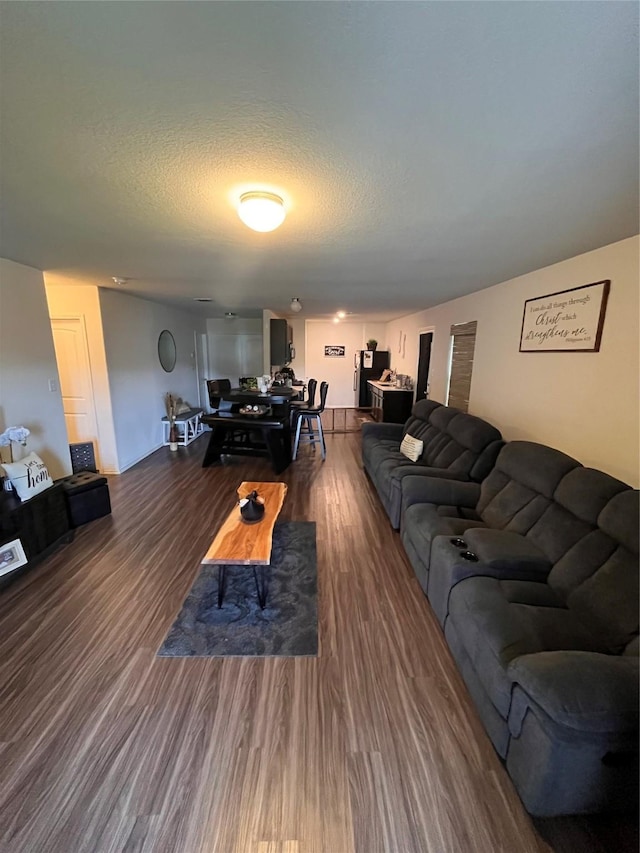 living room with dark wood-type flooring and a textured ceiling