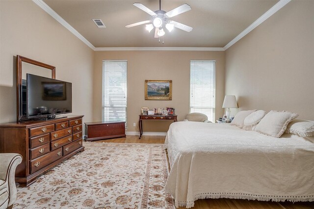 bedroom featuring ceiling fan, crown molding, and light hardwood / wood-style flooring