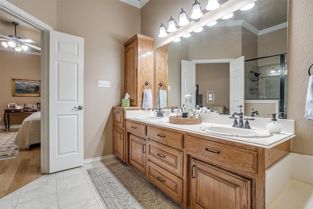 bathroom featuring a shower with door, crown molding, hardwood / wood-style flooring, dual vanity, and ceiling fan