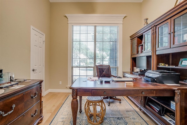 home office with light wood-type flooring and crown molding