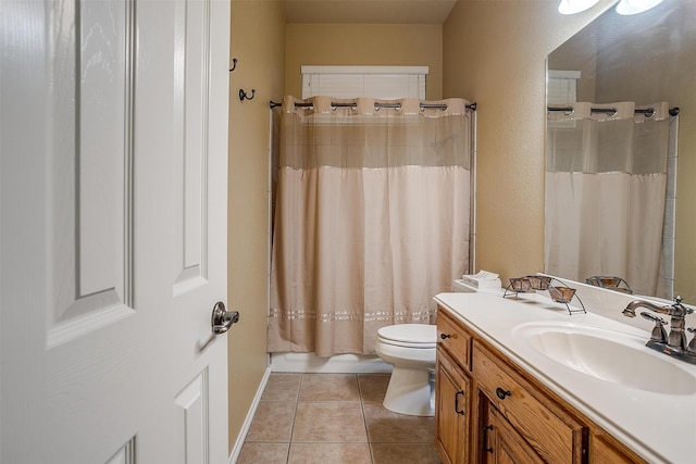 bathroom with toilet, tile patterned floors, and vanity