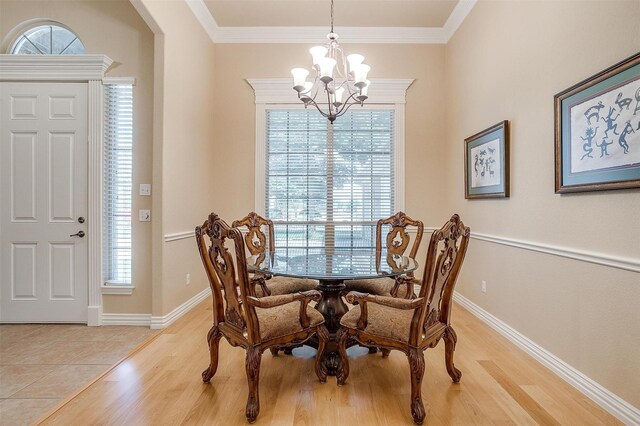 dining room with light wood-type flooring, a chandelier, and crown molding