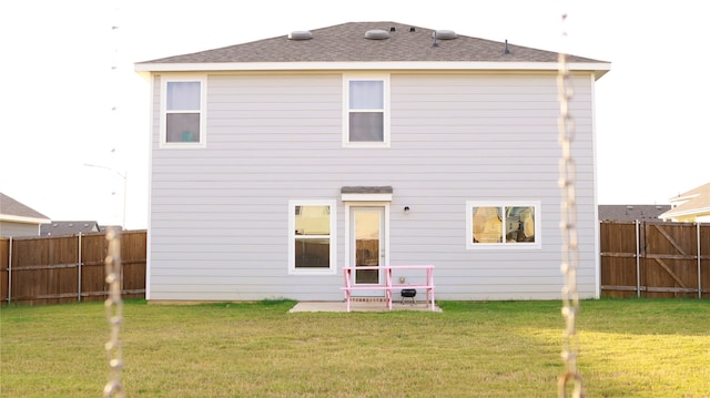 rear view of property featuring a lawn