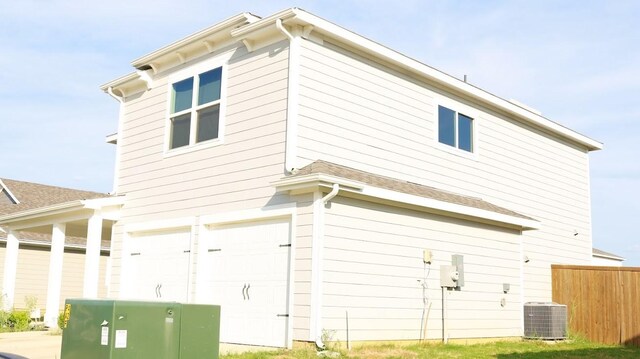 view of home's exterior with central air condition unit and a garage