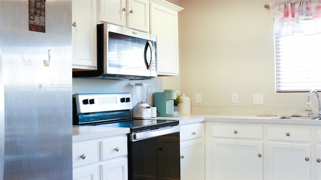 kitchen with white cabinets, sink, and appliances with stainless steel finishes